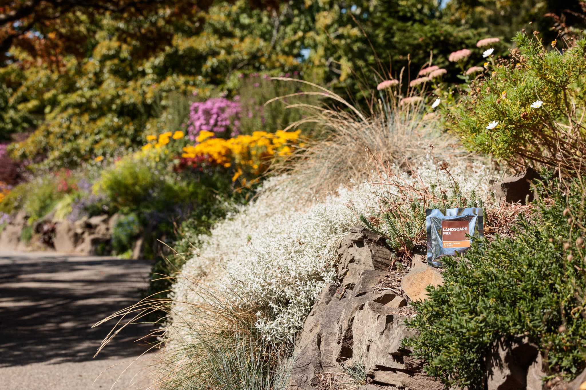 A Landscape Mix pouch tucked into a flowering rockery bed