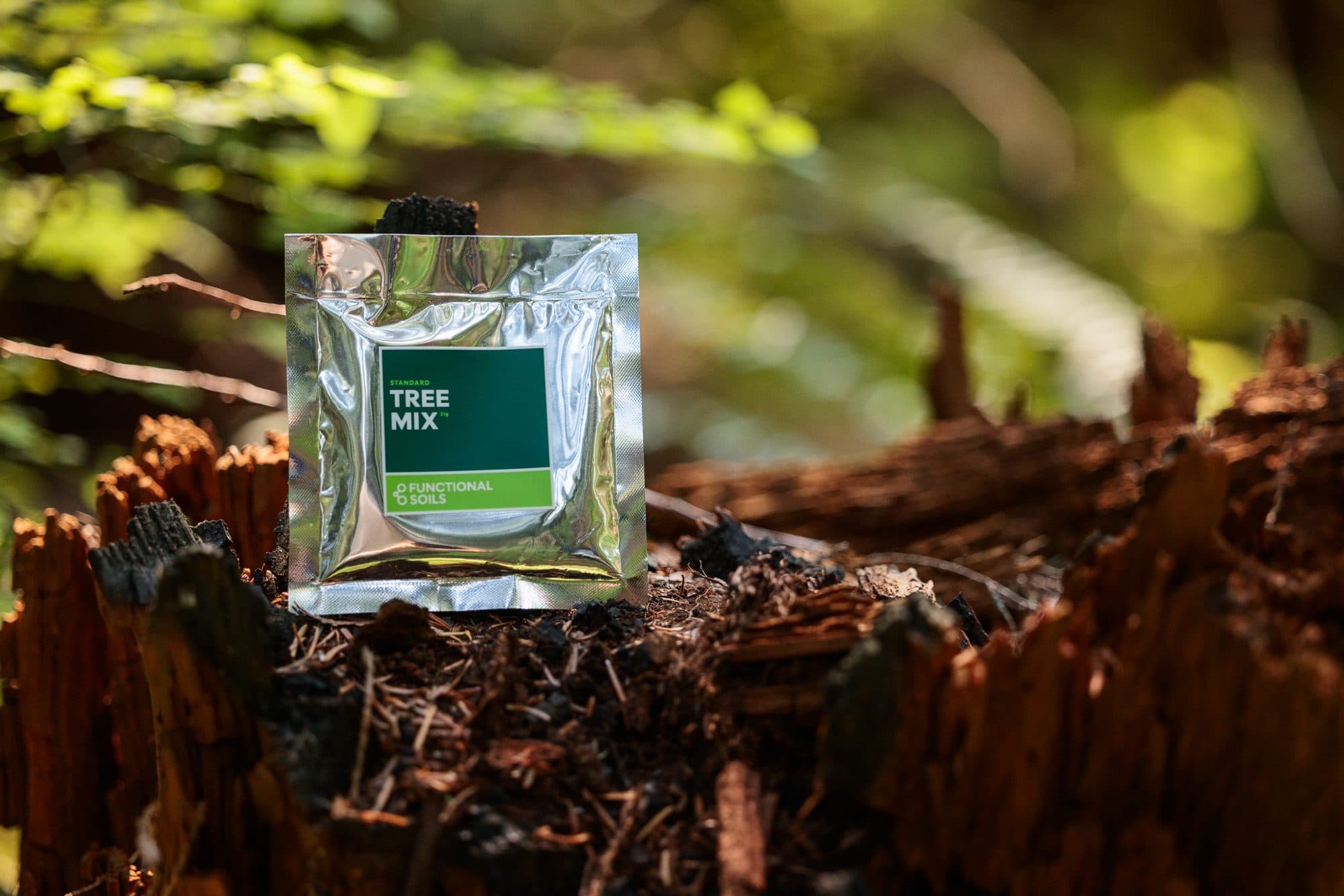 A Tree Mix pouch resting on a mossy stump in the woods